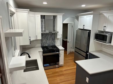 A kitchen with stainless steel appliances and white cabinets.