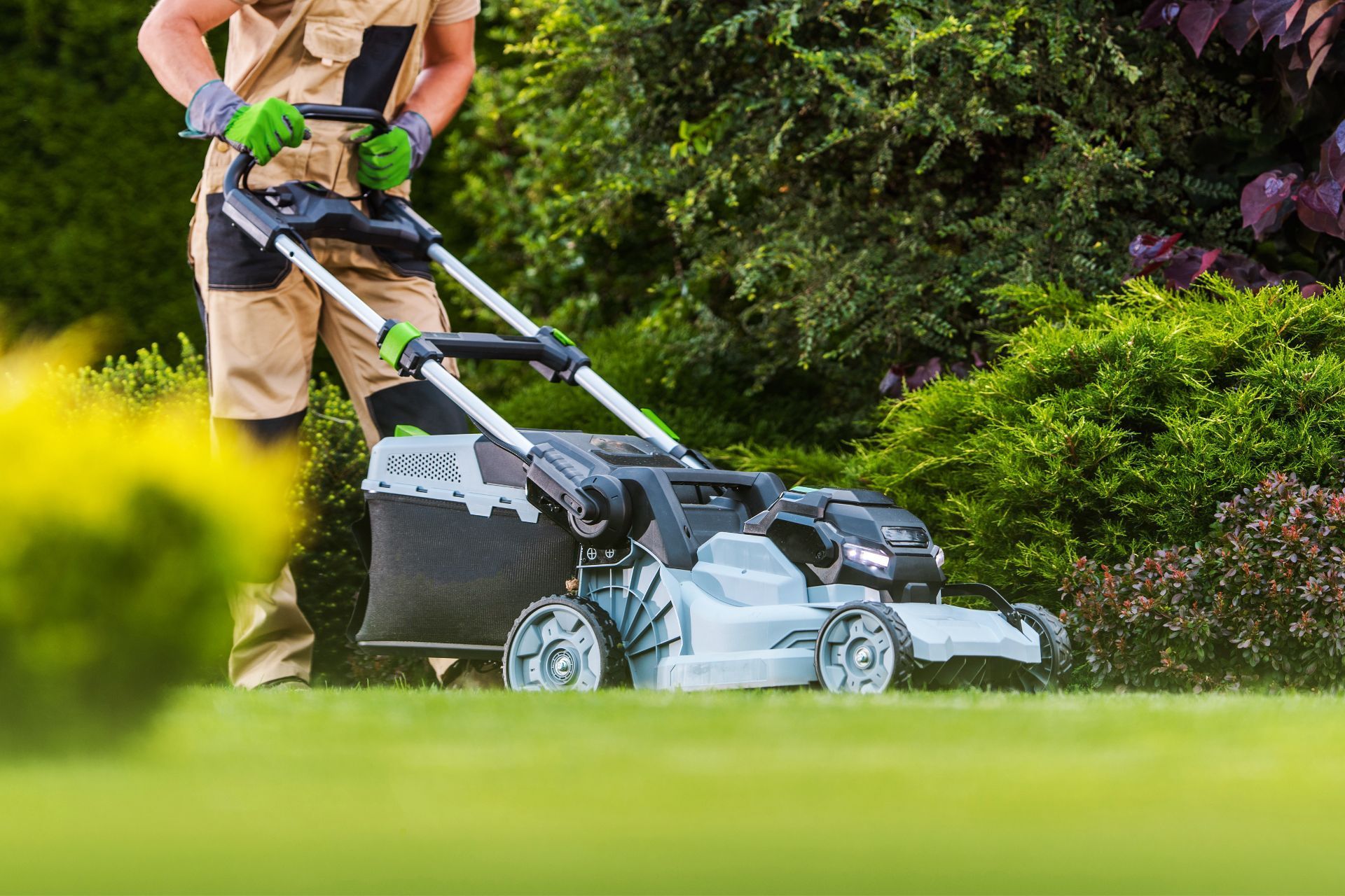 Gardener mowing lawn with electric mower in Athens, GA