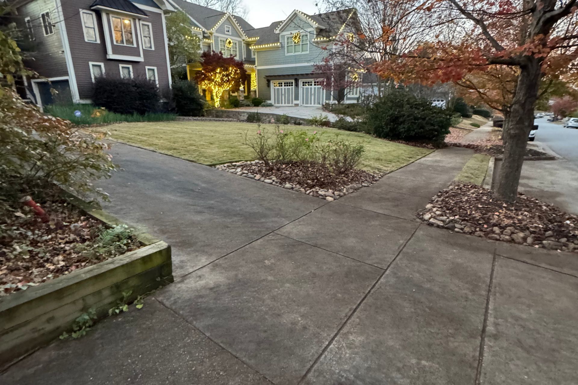 A photo of the front lawn of a house after the leaves have been cleaned up.