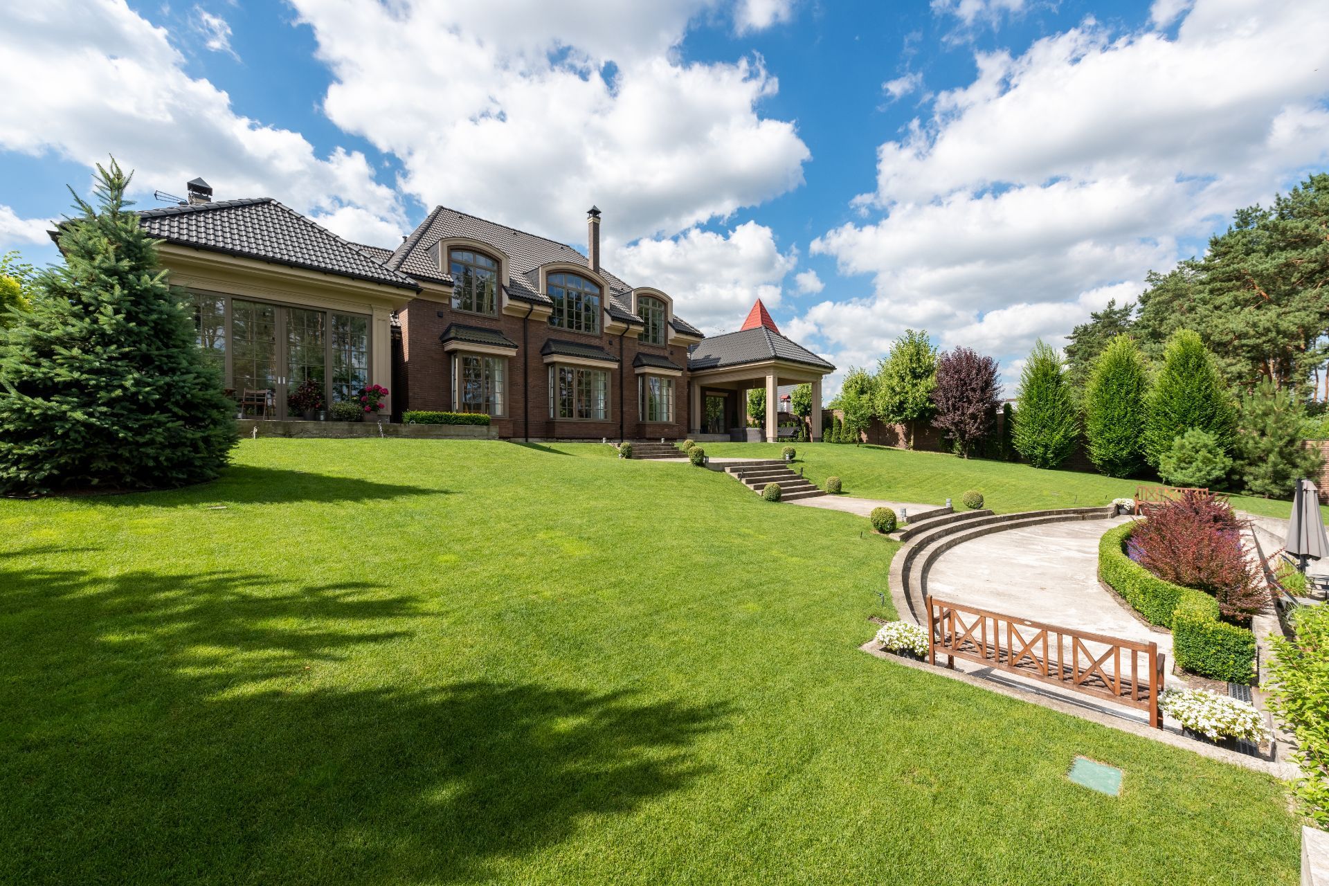 HOA community home with manicured lawn care and landscaping under blue sky