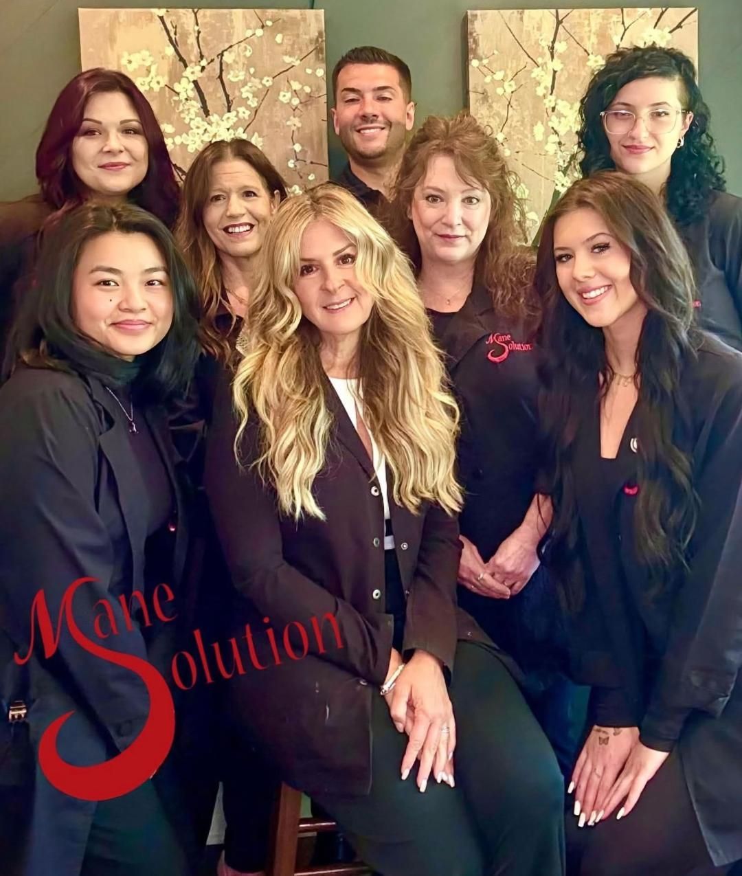 A group of people standing in front of a sign that says mane evolution