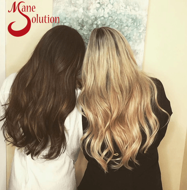 A group of people standing in front of a sign that says mane evolution