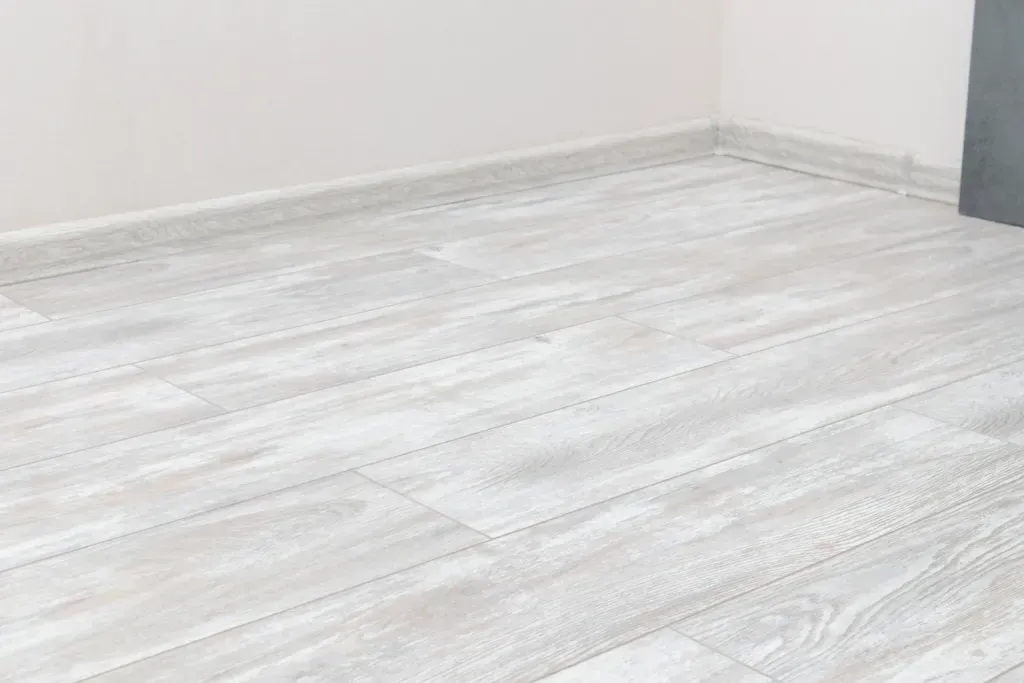 A room with a white tiled floor and a white wall.