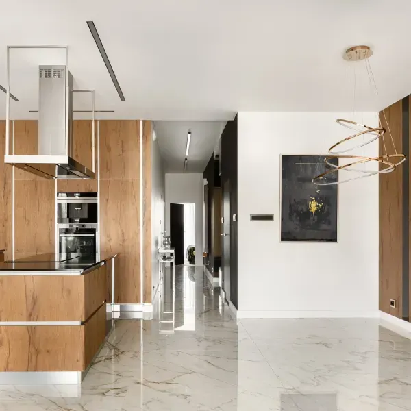 A kitchen with wooden cabinets and a marble floor