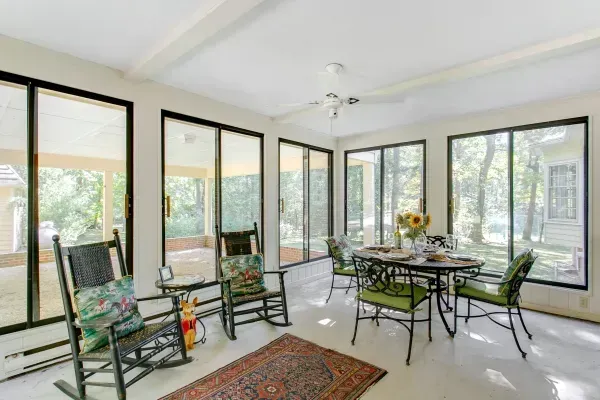 There are rocking chairs and a table in the room.