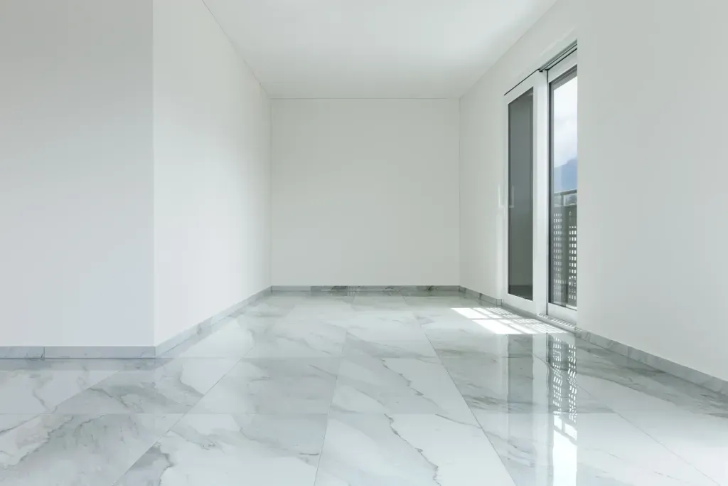 An empty room with a marble floor and white walls.