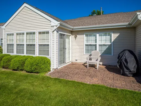 A house with a patio and a chair in front of it.