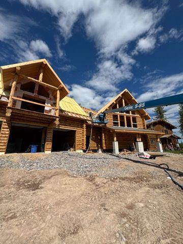 Construction worker applying foam sealant to roof beams.