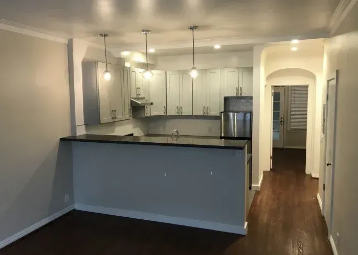 A kitchen with stainless steel appliances and a large island in the middle of the room.
