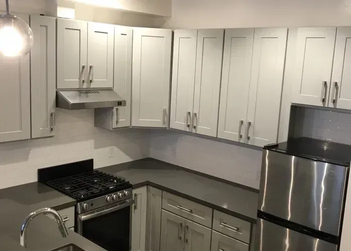 A kitchen with stainless steel appliances and white cabinets.