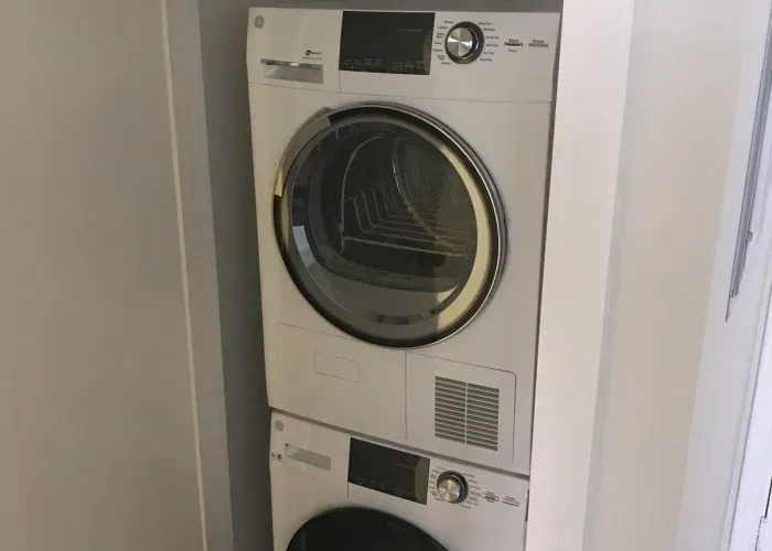 A washer and dryer are stacked on top of each other in a laundry room.