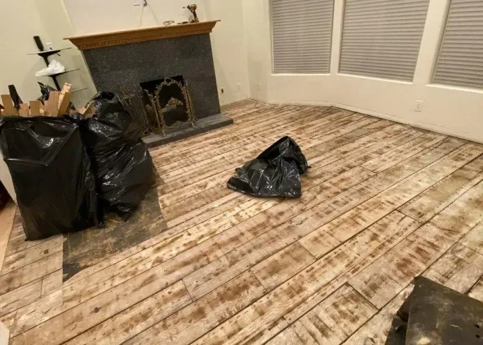 A living room with a wooden floor and a fireplace.
