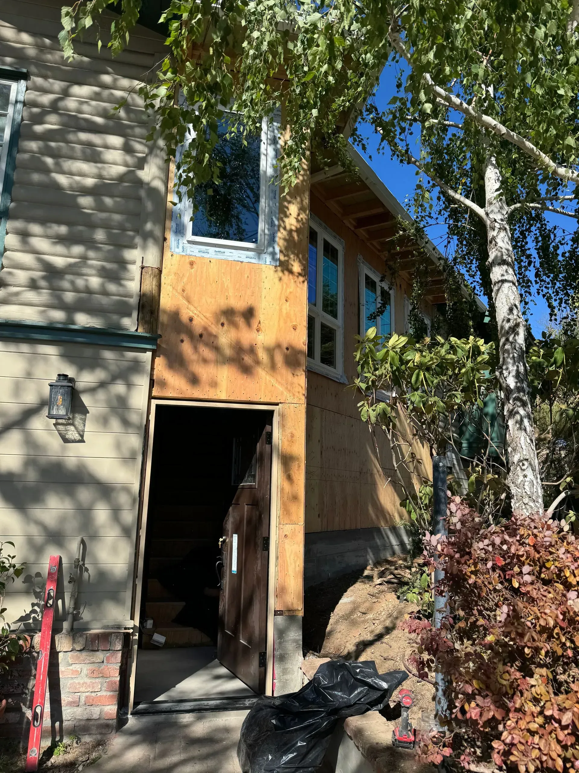 A house is being remodeled with a wooden door and windows.