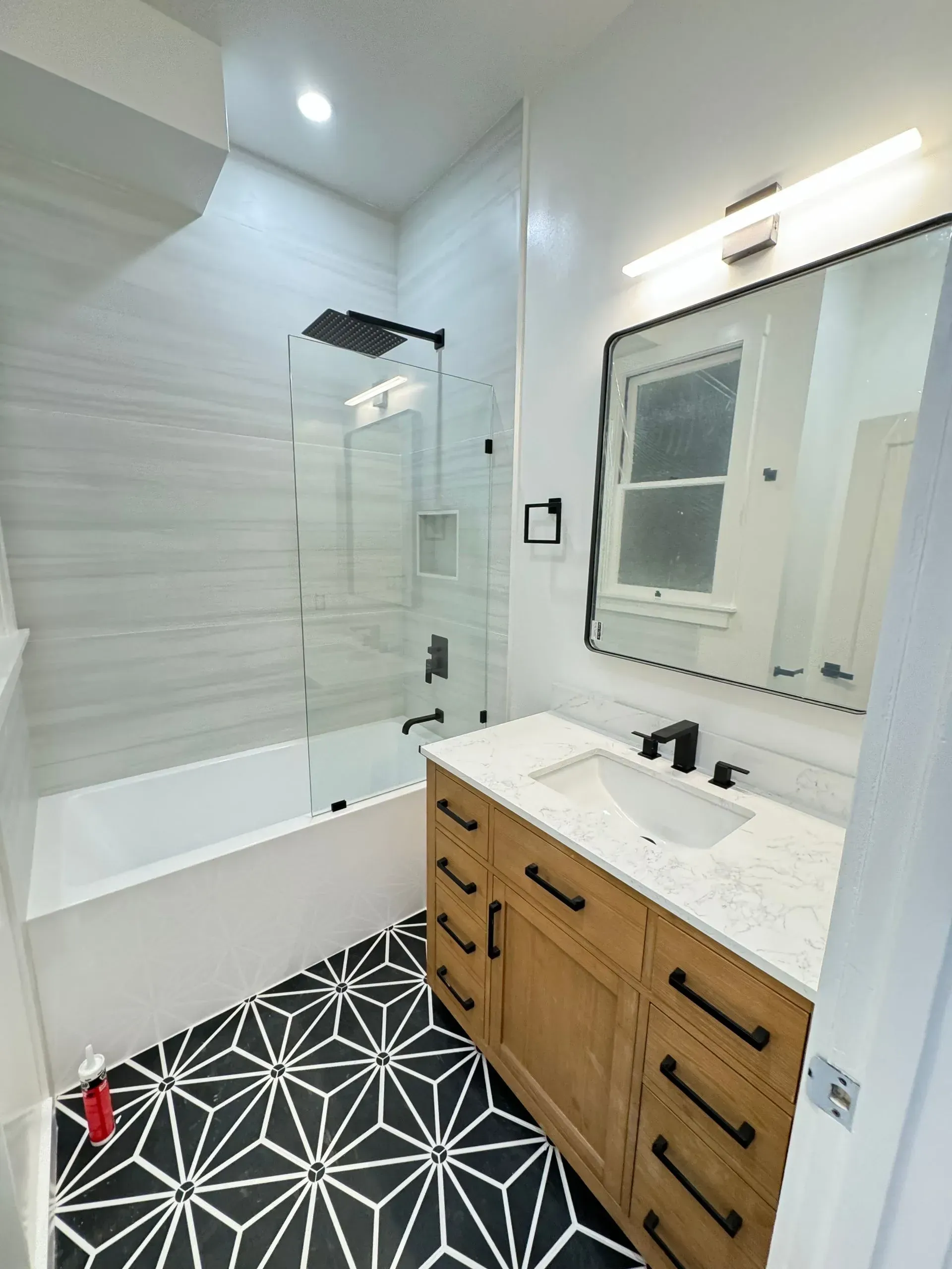 A bathroom with a sink , bathtub and mirror