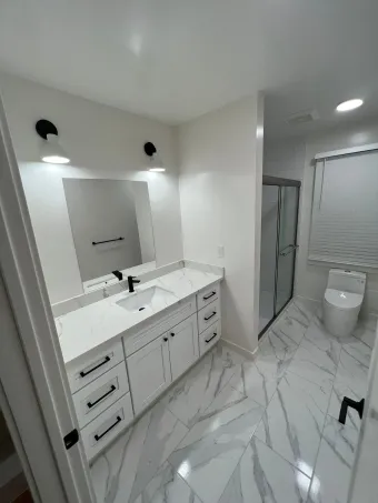 A bathroom with a sink , toilet , and mirror.