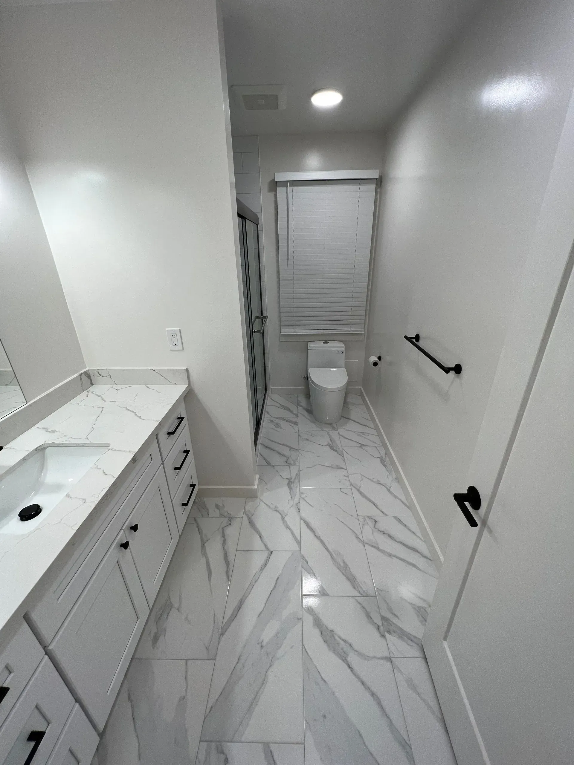A bathroom with a toilet , sink and mirror.
