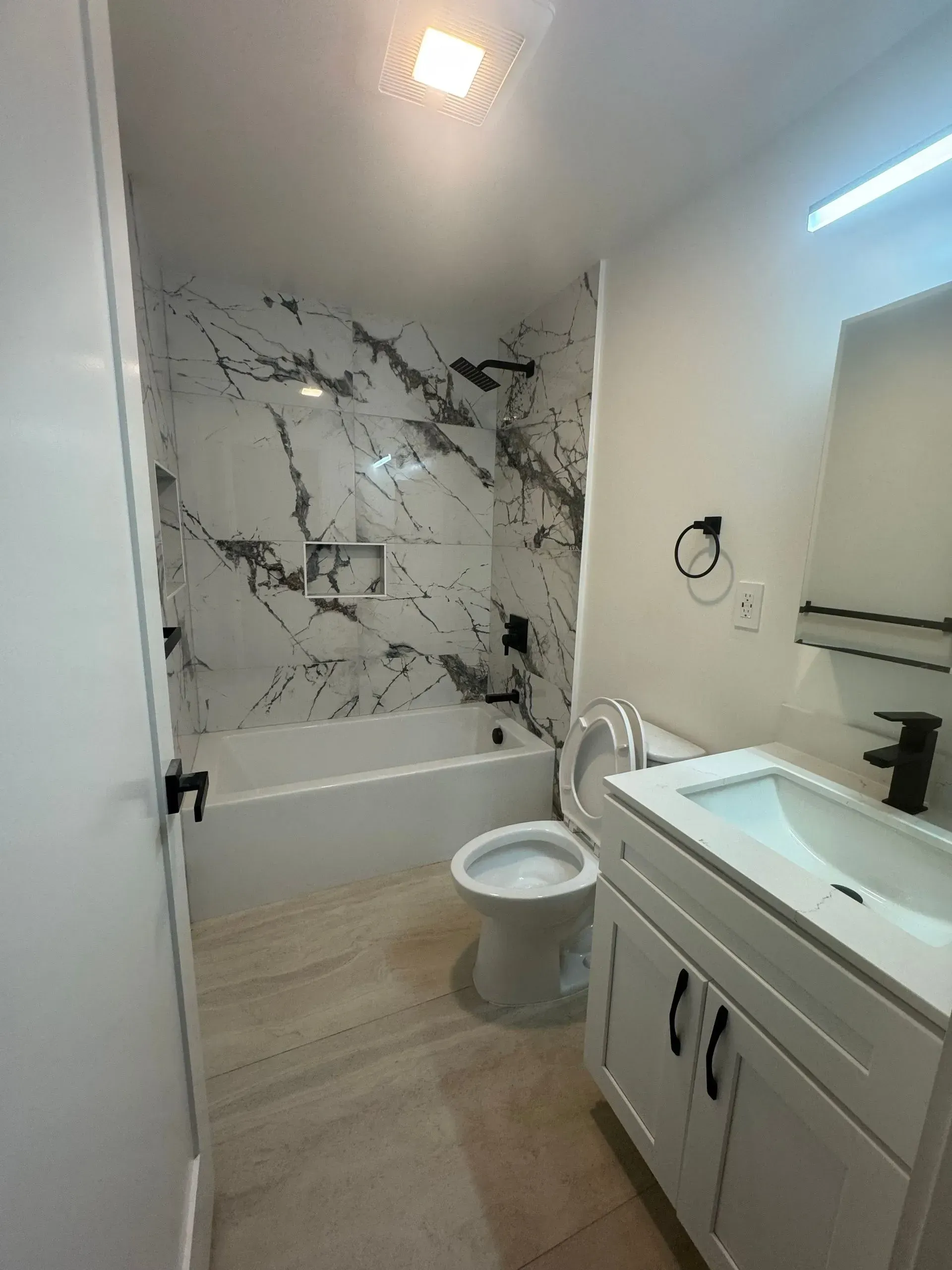 A bathroom with a toilet , sink , and bathtub.