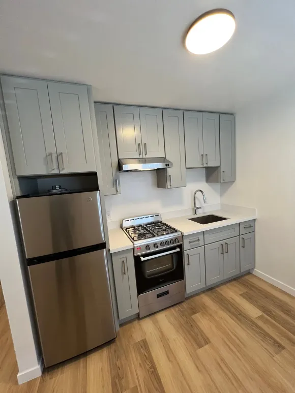 A kitchen with stainless steel appliances and white cabinets
