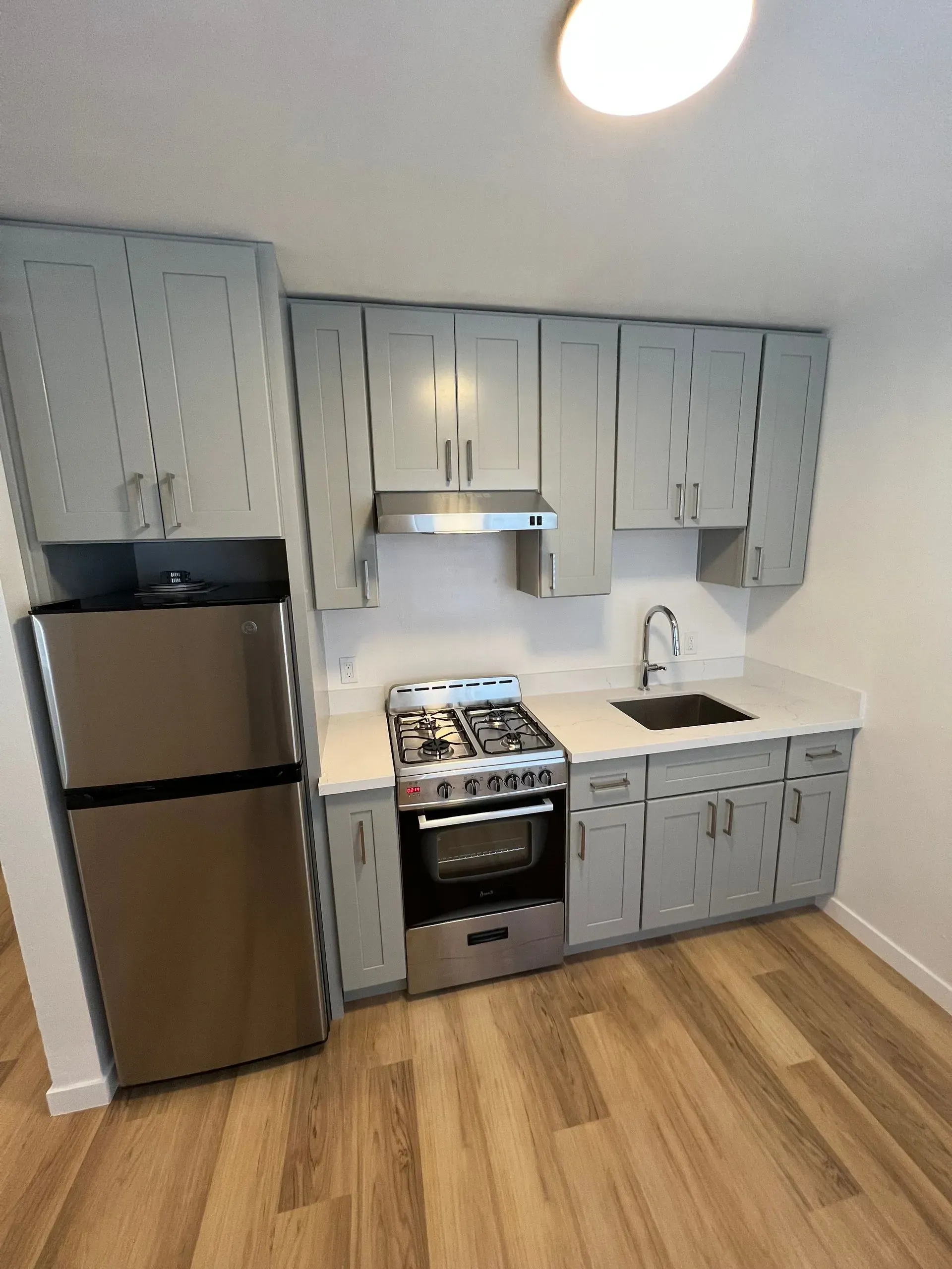 A kitchen with stainless steel appliances and gray cabinets