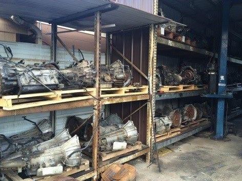 Shelves holding used automotive transmissions at a salvage yard.