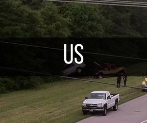 Car tangled in power lines after accident; tow truck and pickup truck at scene.