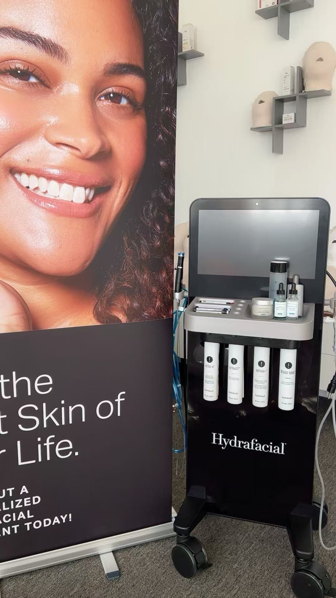 A woman is smiling in front of a sign that says the skin of my life.