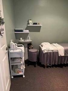 A room with two beds , a sink , and a stool