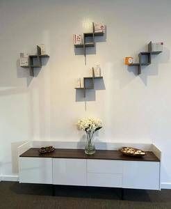 A living room with a white dresser and a vase of flowers on it