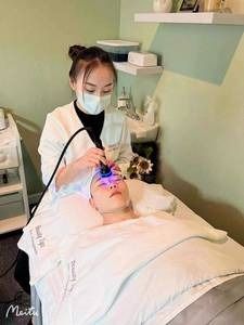 A woman is giving a man a facial treatment in a beauty salon