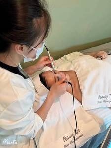 A woman is laying on a bed getting a facial treatment