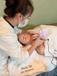 A woman is giving a woman a facial treatment at a beauty salon