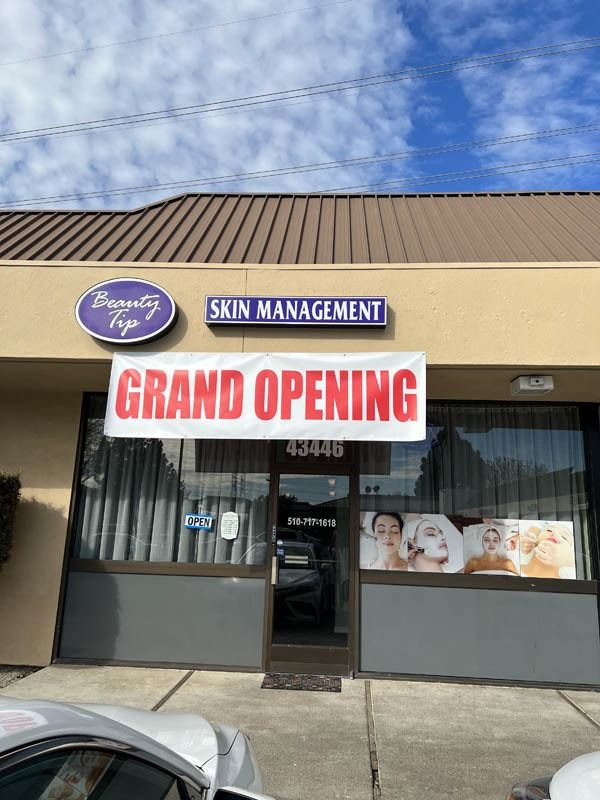 A store front with a sign that says `` grand opening ''.