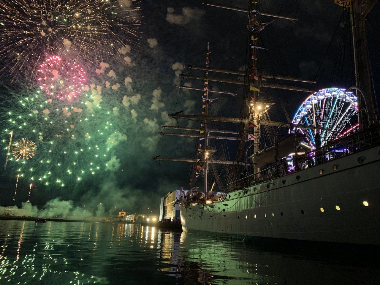 Fireworks are displayed over a boat in the water