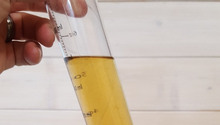 Image of a blonde beer in a graduated hydrometer cylinder.