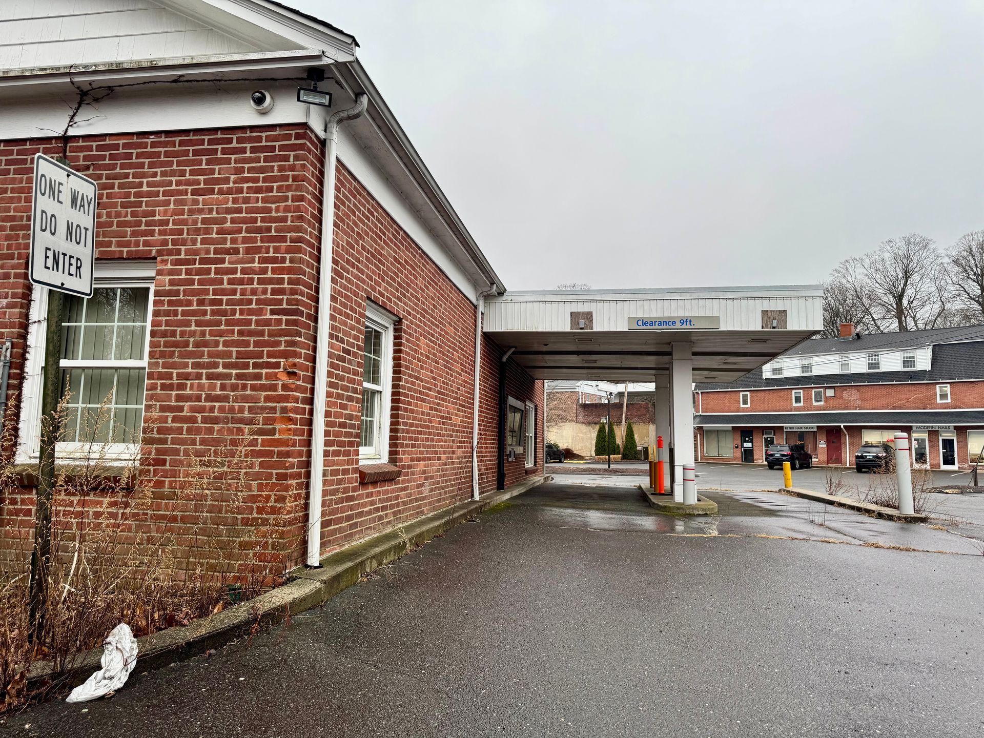Red brick building with a drive-through, cloudy day.