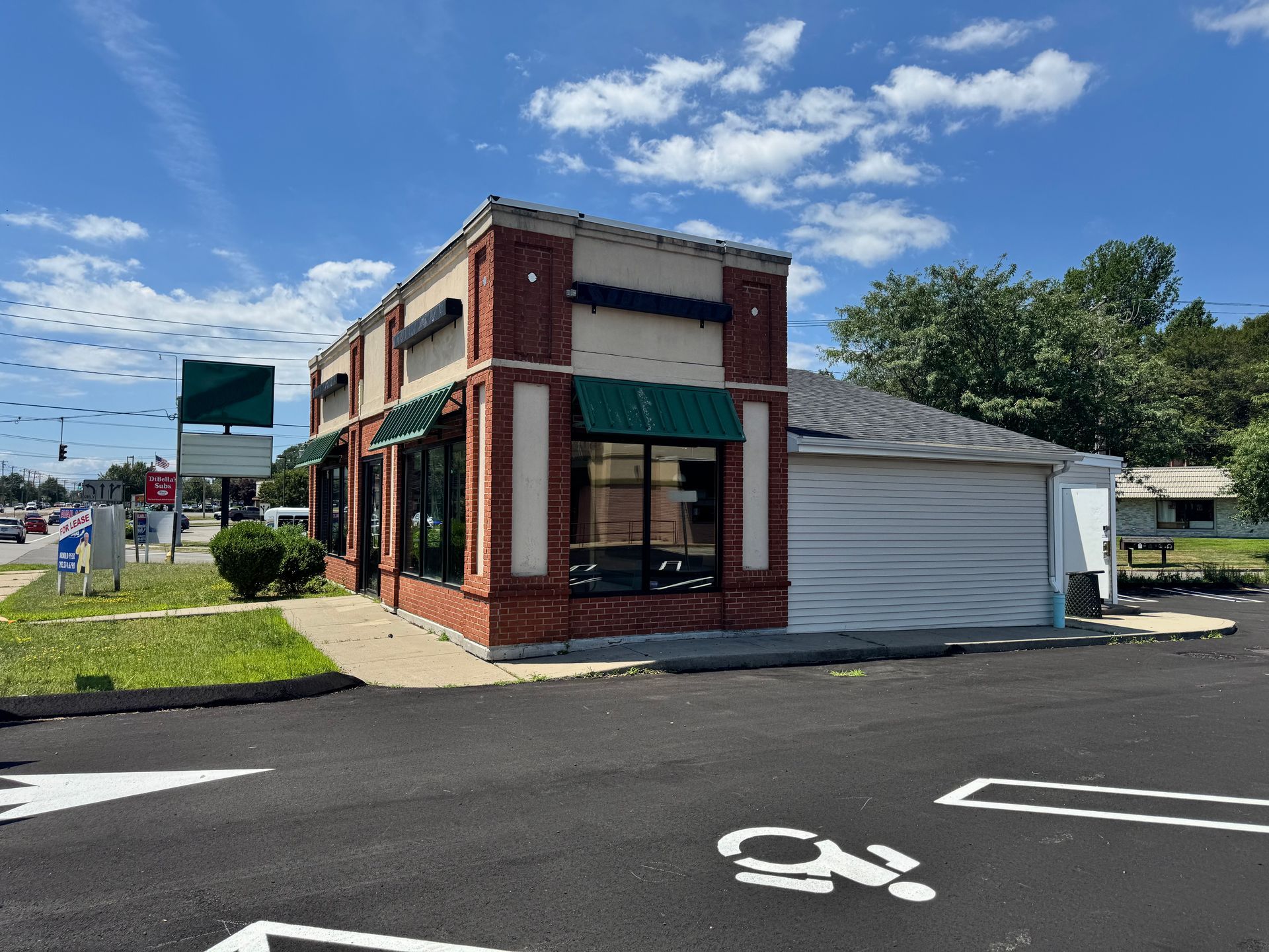 A brick building with a drive-through window under a bright blue sky.