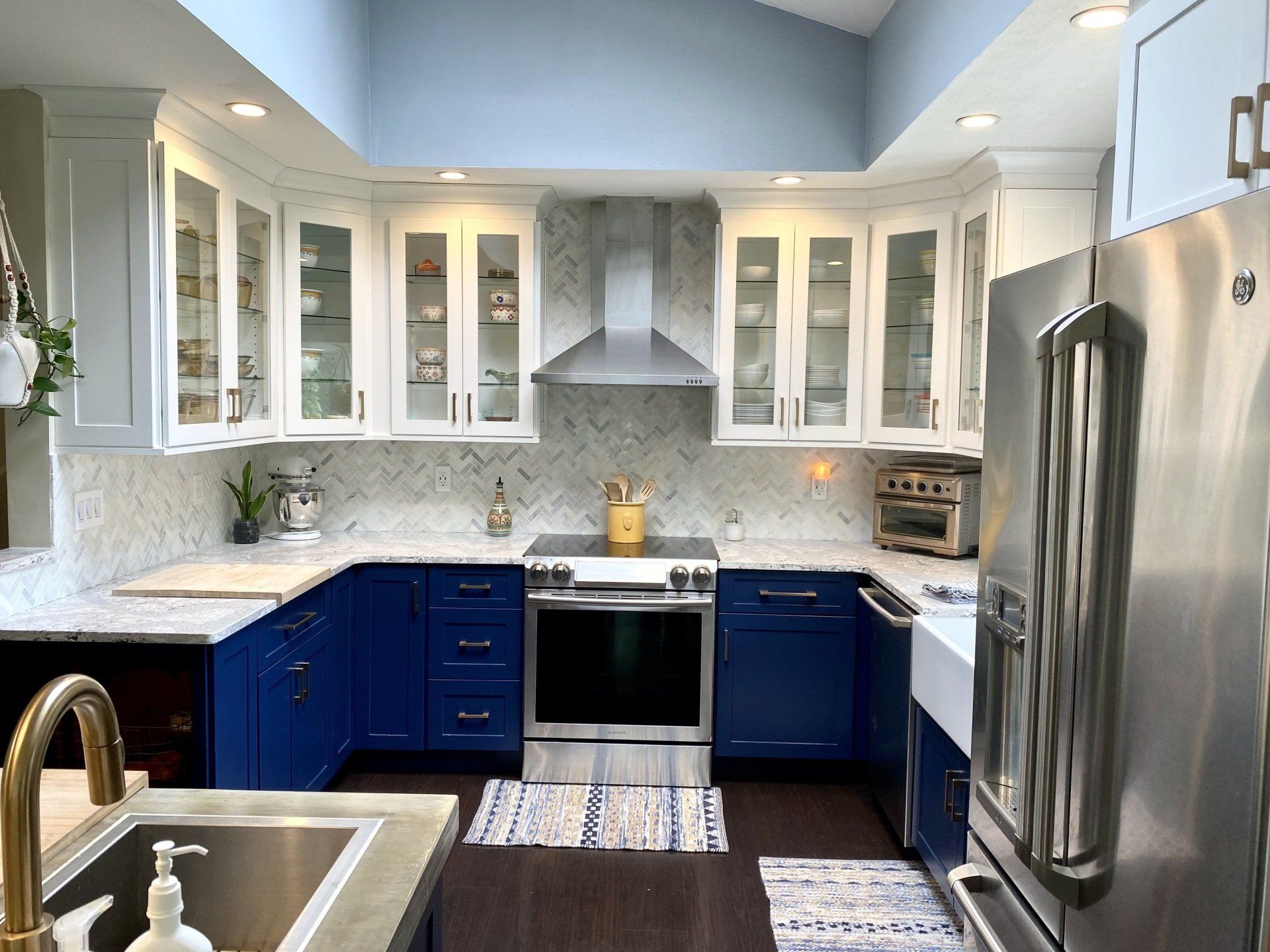 Blue and white kitchen with a stainless steel range and refrigerator.