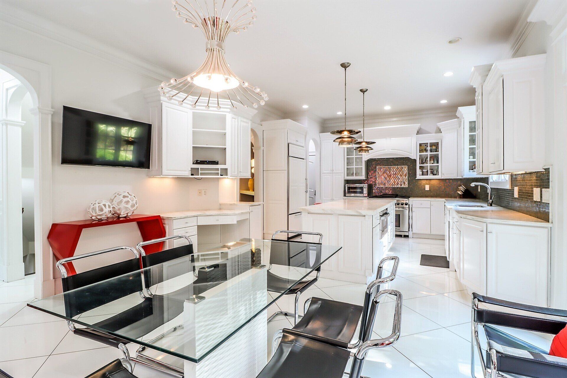 Bright white kitchen with glass table and chairs, red accents.
