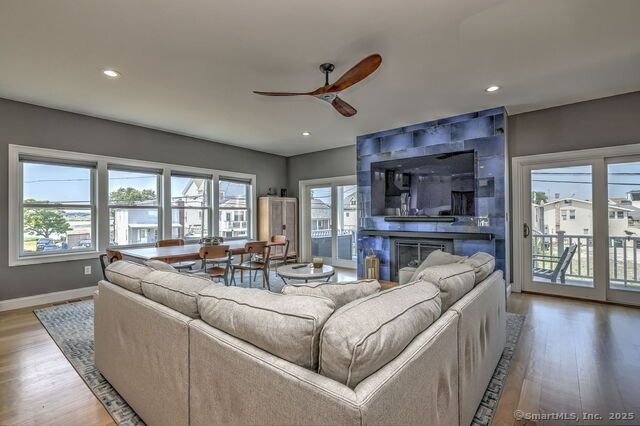 Spacious living room with a sectional sofa, dining table, and blue-tiled fireplace.
