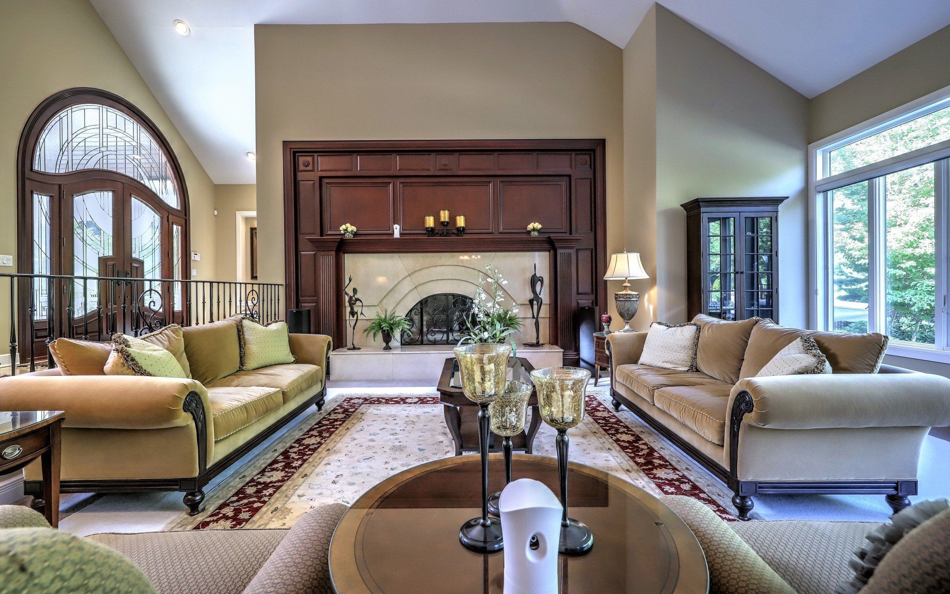 Elegant living room with couches, fireplace, and arched windows.