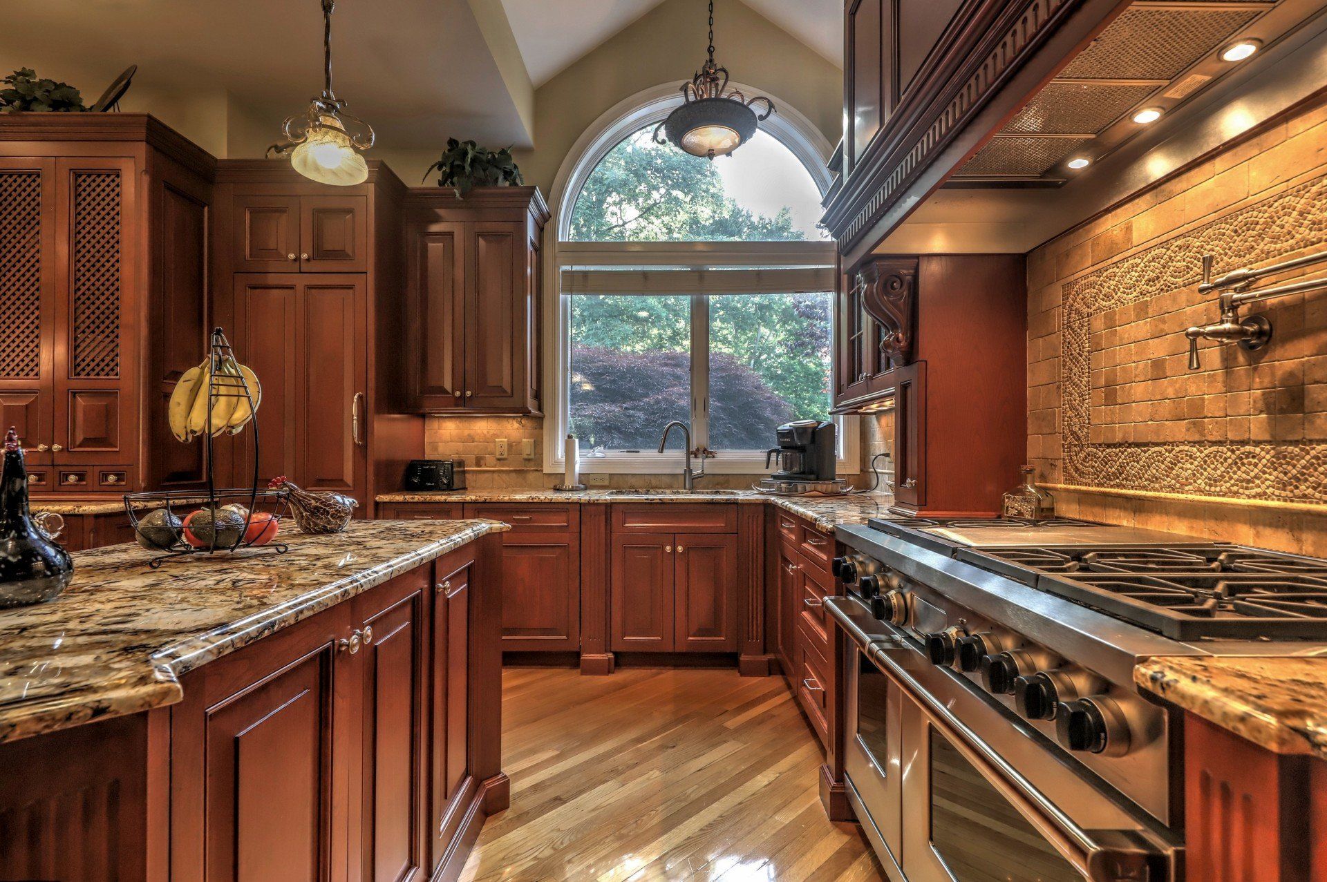 Elegant kitchen with wood cabinets, granite countertops, and stainless steel range.