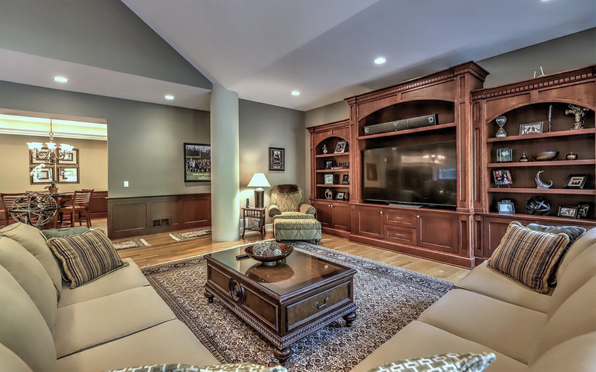 Living room with sectional sofa, built-in entertainment center, and view to dining room.