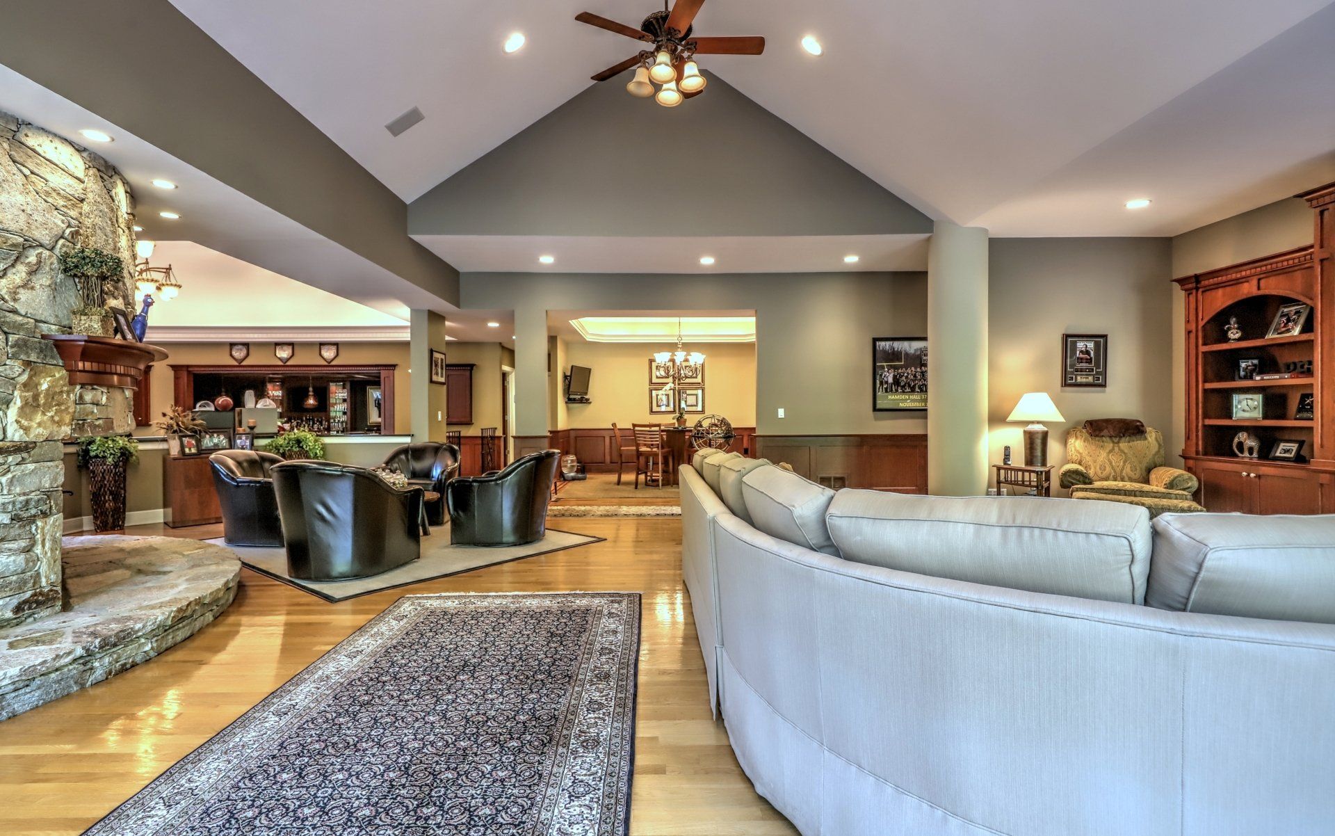 Spacious living room with stone fireplace, hardwood floors, and comfortable seating.