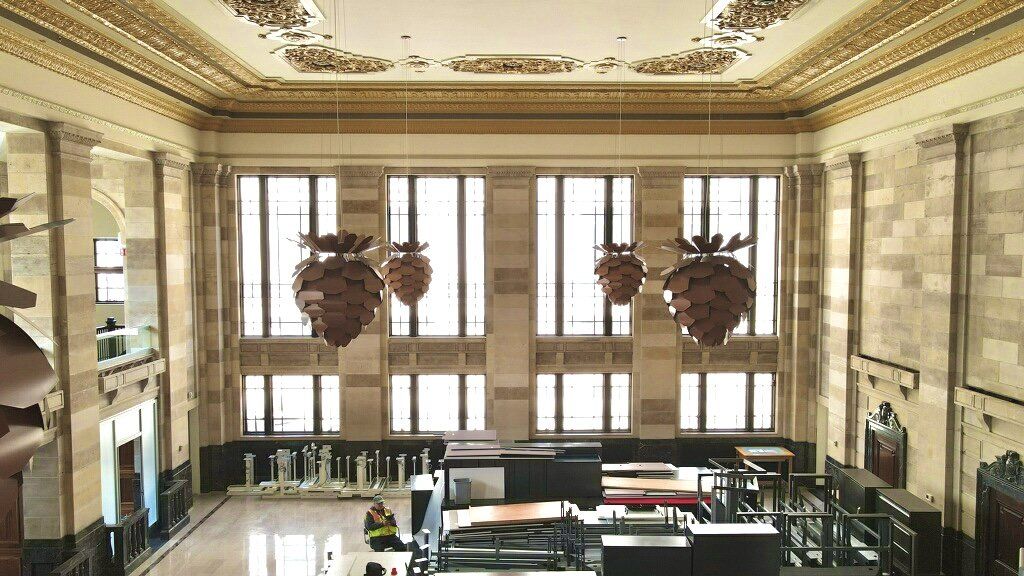 High-angle view of a grand room with large windows, ornate ceiling, and decorative hanging light fixtures.
