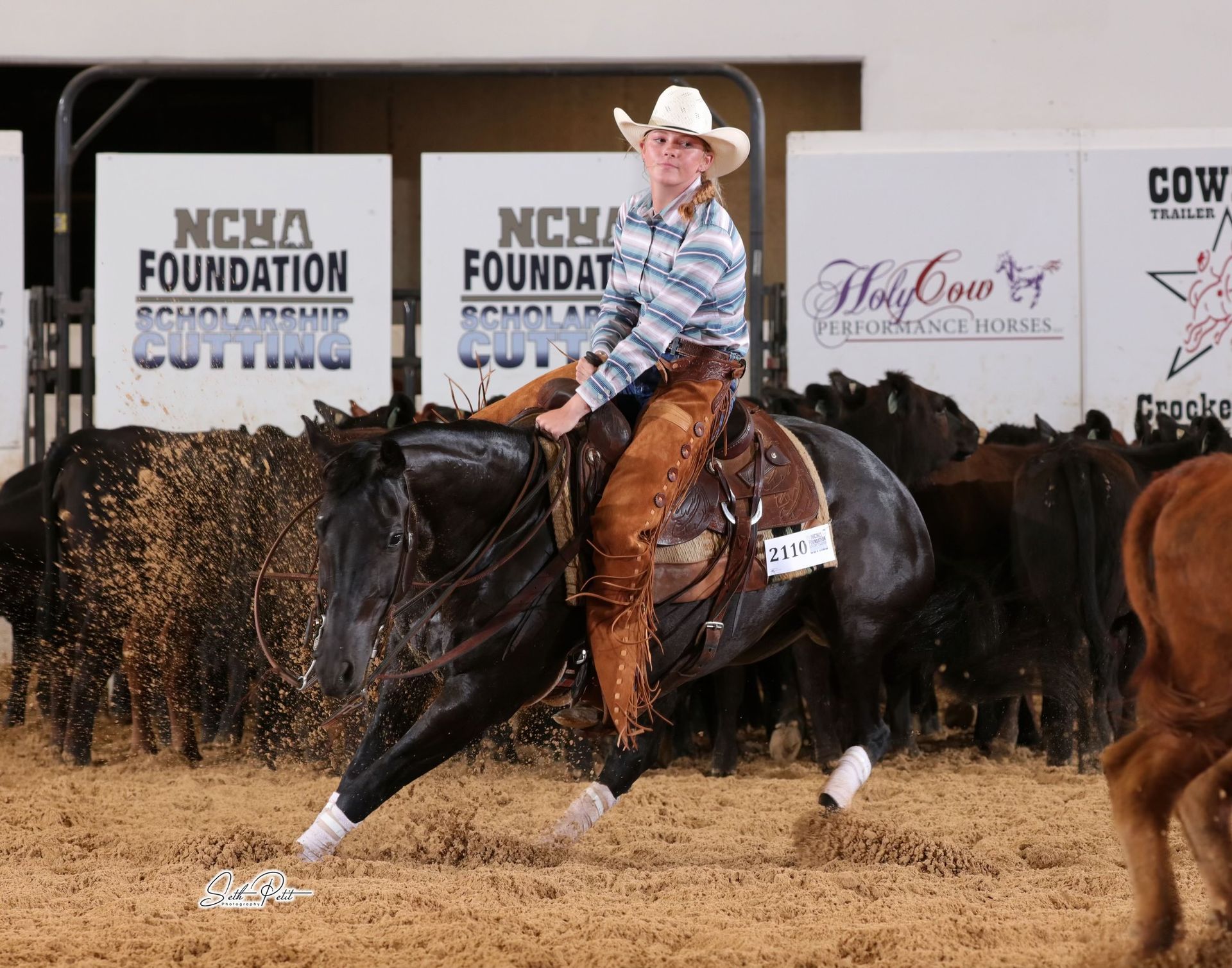 A man riding a horse in front of signs that say ncha foundation