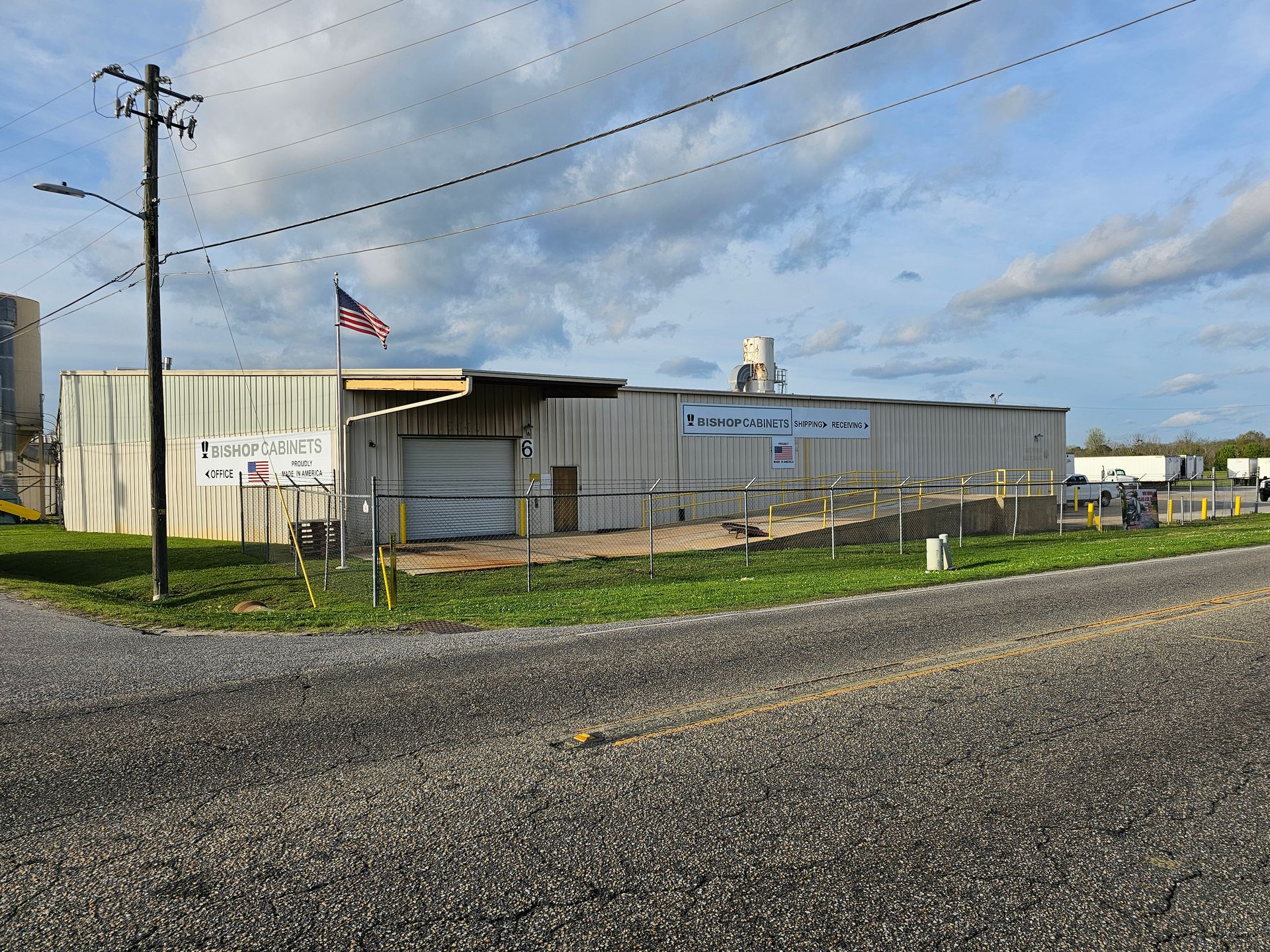 A large white building with an american flag flying in front of it.