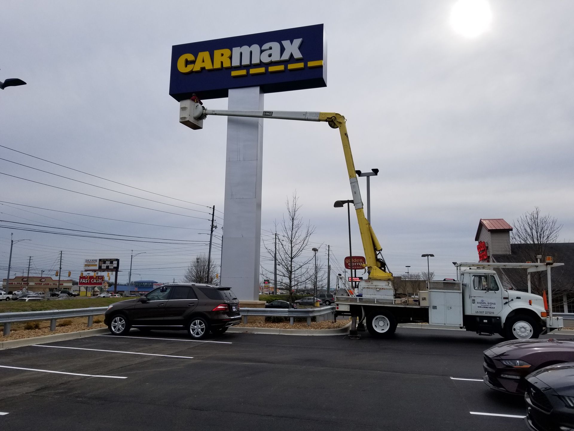A carmax sign is being installed in a parking lot