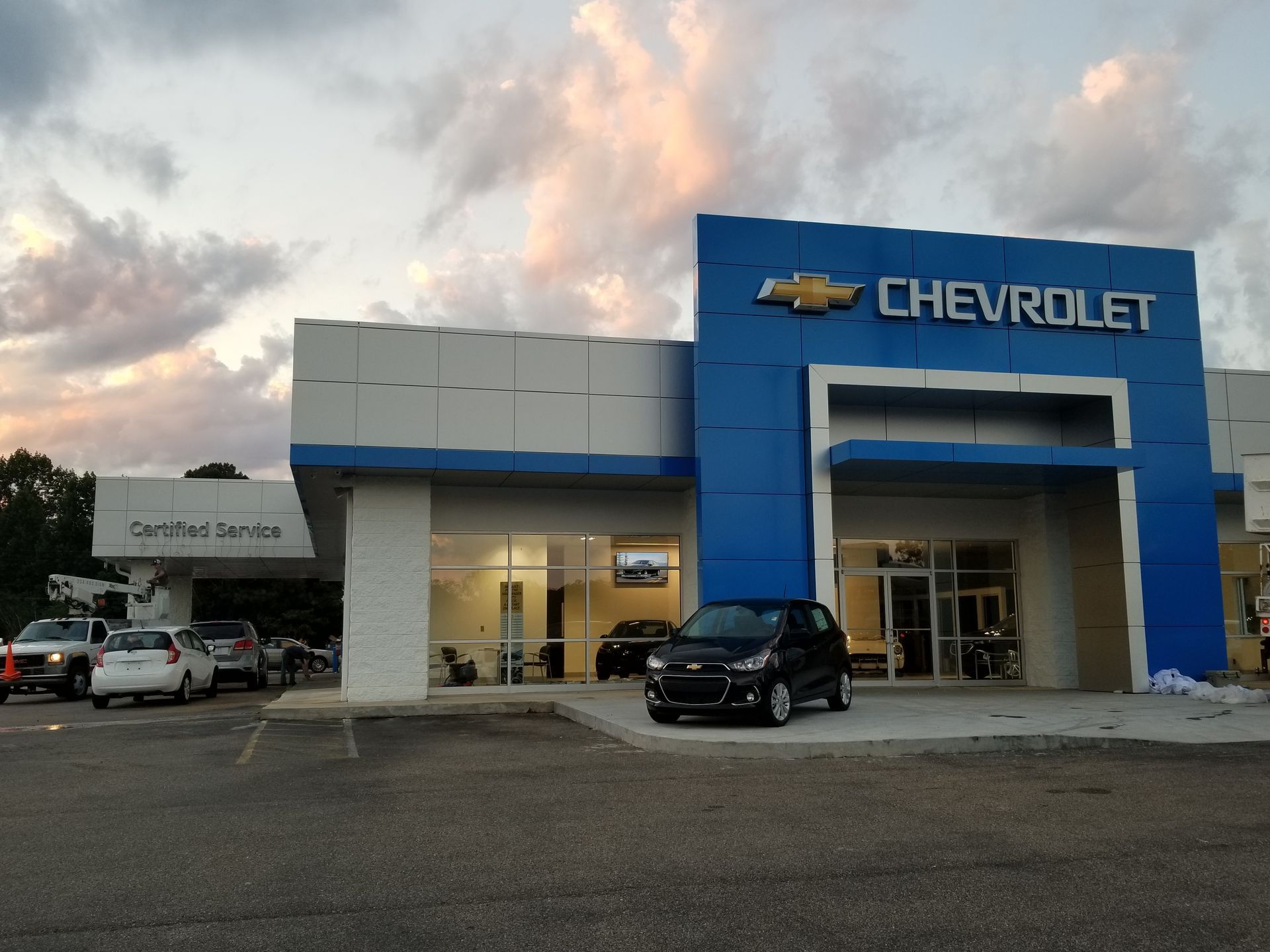A car is parked in front of a chevrolet dealership