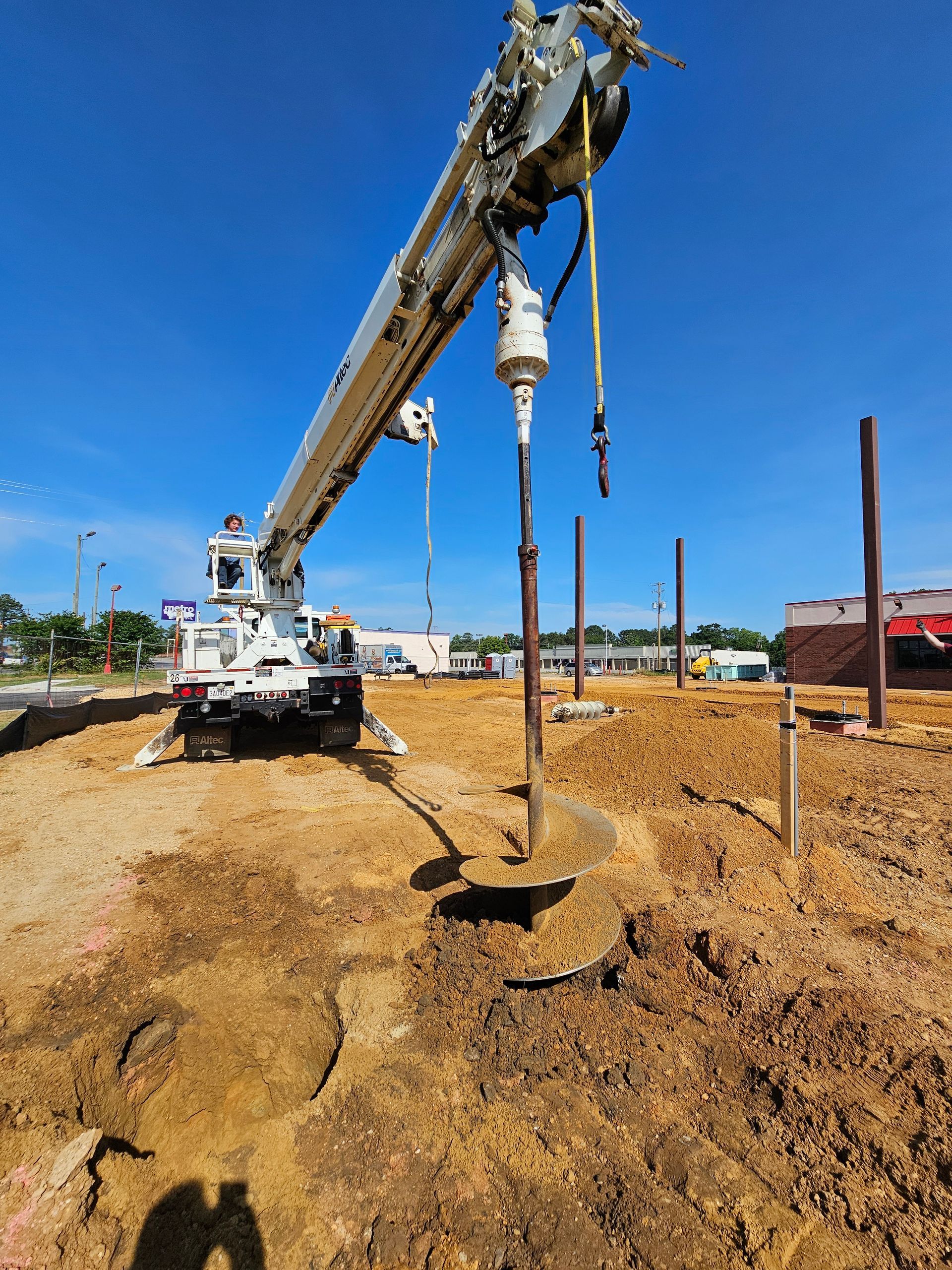A crane is digging a hole in the ground.