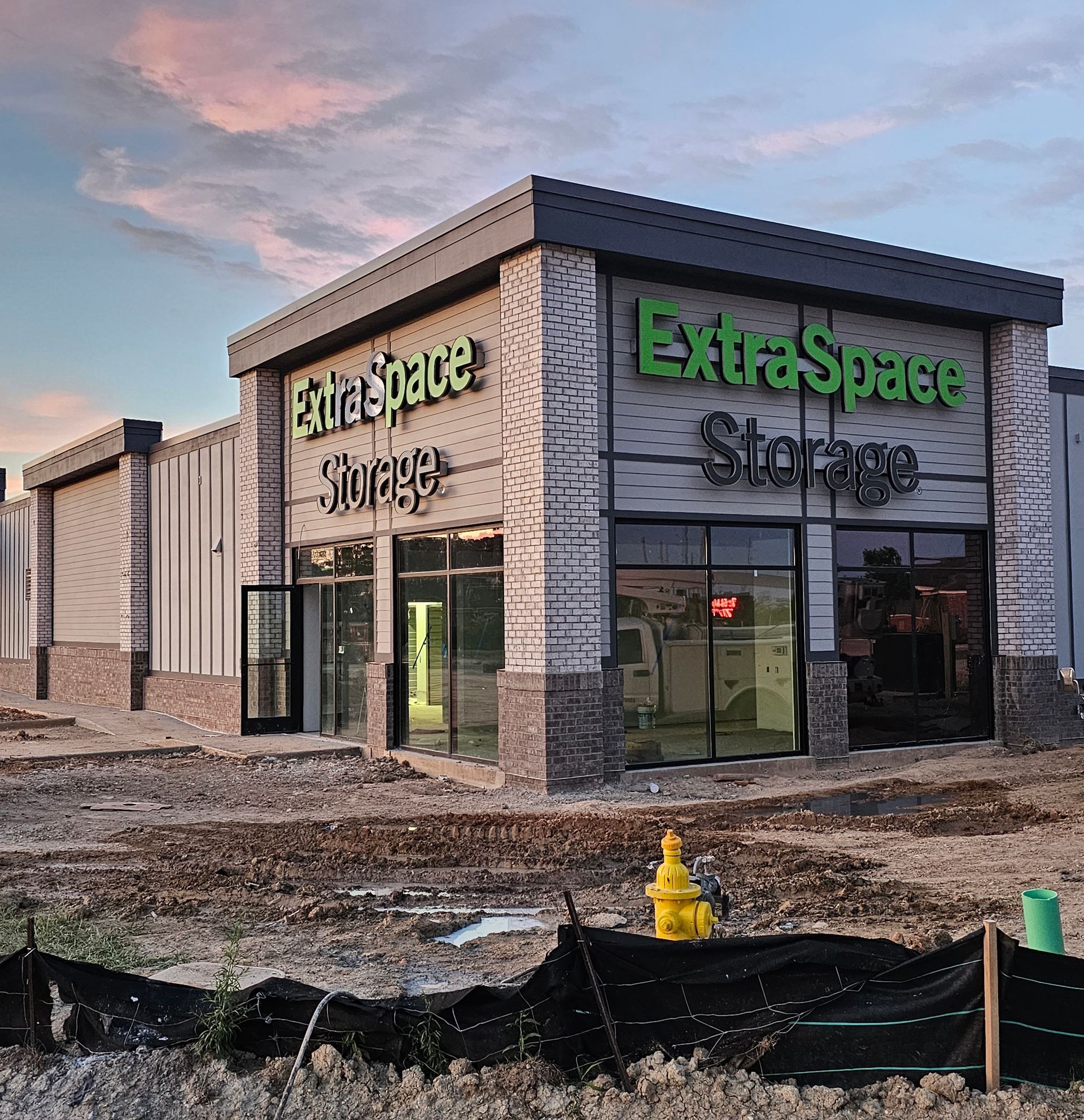 A large building with green letters that says extra space storage